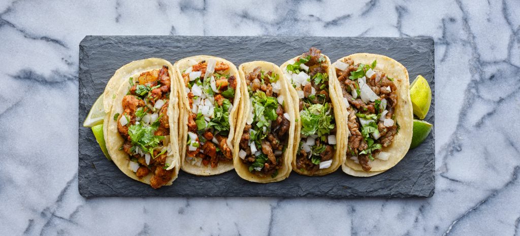 row-of-mexican-street-tacos-on-slate-with-carne-as-2023-11-27-05-22-54-utc